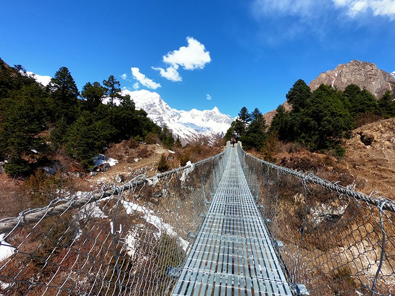 Suspension bridge with view of Mt. Manaslu