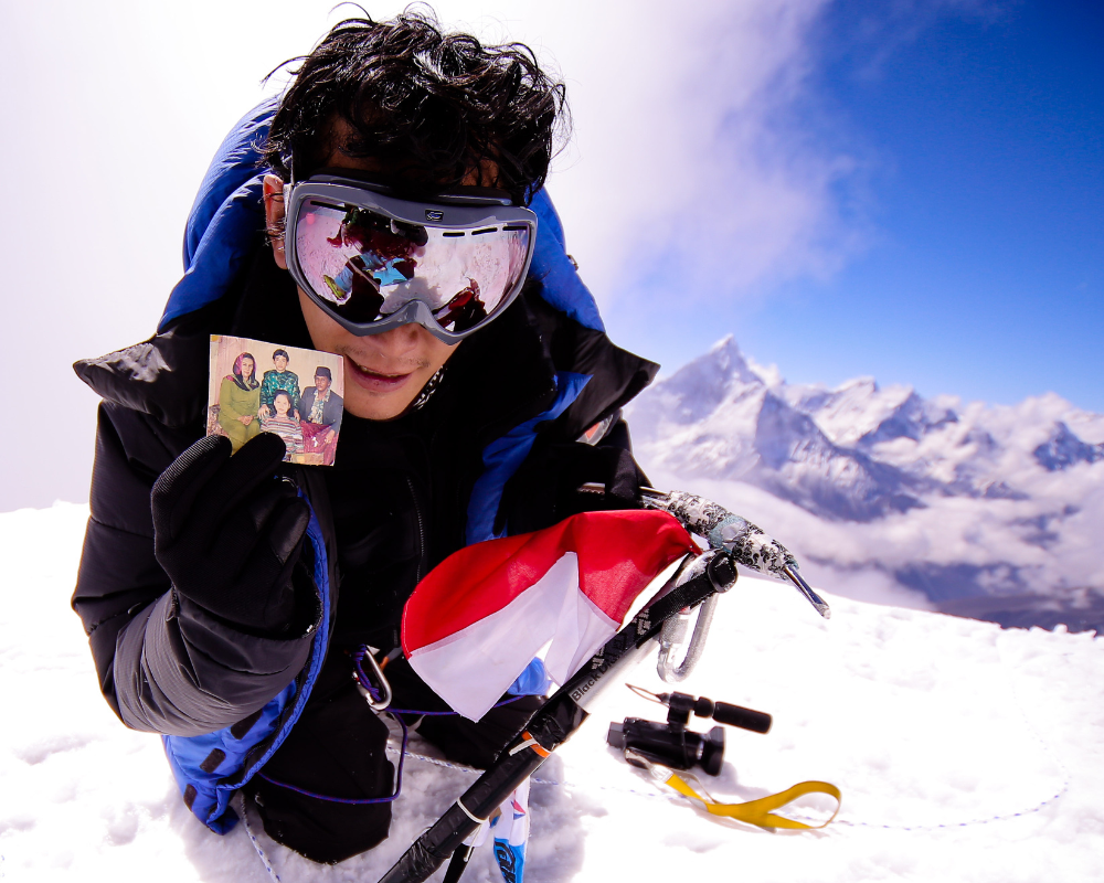 A climber shows a photo at the summit of Lobuche East peak.