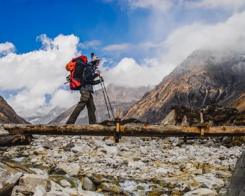 Hiker Passing Through Wooden Bridge On The Trail Of Manaslu Region