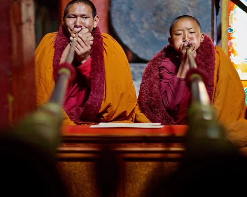 Two Young Monks Play Dung Chen During A Prayer